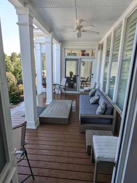 The Ultimate Guide to Designing Your Perfect Trex Deck: Trends, Tips, and Must-Have Features 3 Cozy covered porch featuring a stylish Trex deck with comfortable seating and elegant columns—perfect for inspiration on Trex deck ideas.